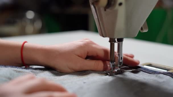 Жіночі руки роблять лінію на джинсах. крупним планом швейна машинна голка . — стокове відео