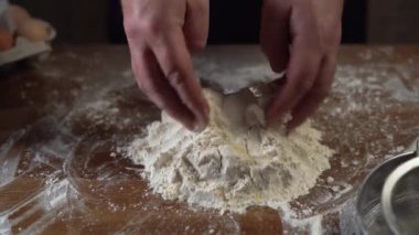 Bir aşçının erkek eli, hamuru malzemelerden yoğurmaya başlar. Konsept: tatlı, pasta, hamur, lezzet, saf ürün, pişirme, restoranlarda çalışma,