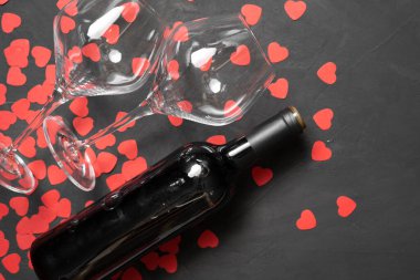 Sevgililer Günü 'nde şarap kadehleri ve taş zeminde kalpler olan tebrik kartı şişesi. Üst görünümü kopyala.