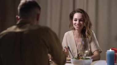 Mutlu evli çift yemekte midye yiyor, gülümsüyor ve romantik bir akşam yemeğinde eğleniyor. Mutfaktaki mum ışığında çok hassas anlar. Bir erkek kadınını besler..