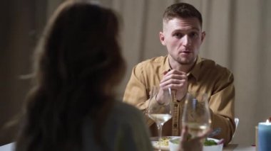 Genç bir çift romantik bir ortamda restoranda yemek yiyor. Sevgililer Günü 'nde romantik bir akşam yemeğinin tadını çıkaran bir çift..