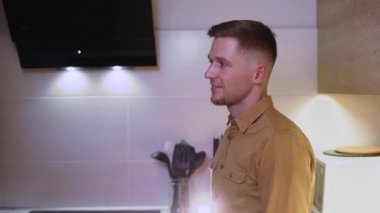 Mutlu, sevgi dolu genç çift, evdeki mutfakta. Güzel beyaz kadın tatilde sevgilisini öpüyor..