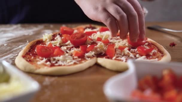 Close up Pizza Italia yang lezat dengan keju mozzarella dan saus pesto. Juru masak menempatkan irisan tomat ceri yang lezat. Proses memasak — Stok Video