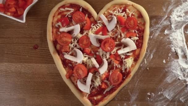 Włoskie jedzenie. Duża surowa pizza w formie leży na stole, słowo jest napisane palcem na mące. koncepcja kolacji na Walentynki, lub rocznica. — Wideo stockowe