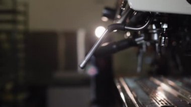 İş yerinde kahve makinesi var. Cappuccino için süt karıştırıyorum. Espresso ve süt buğulama. Kahveci kahve dükkanında sıcak süt köpüğü hazırlar..