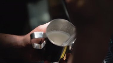 Demir bir sürahide kapuçino için köpüklü süt. Latte hazırlanıyor.