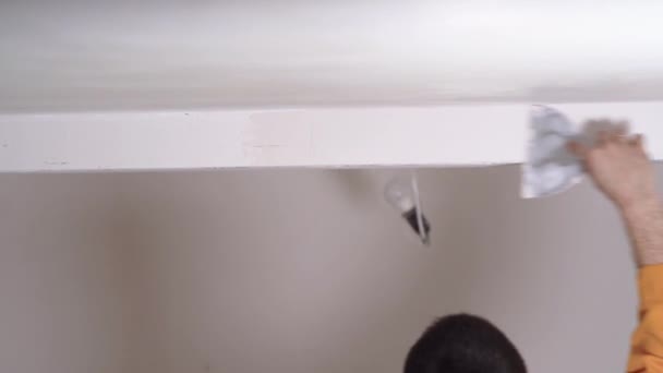 Main étroite d'un homme plâtre le plafond, concept de maître constructeur sur le chantier de construction — Video