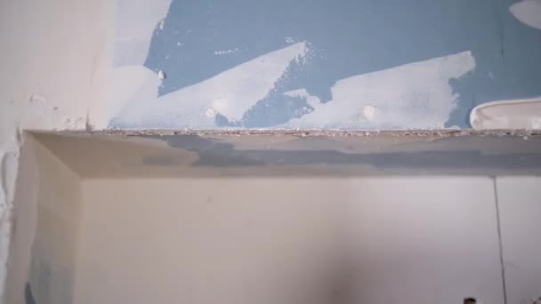 Macun bıçağı duvara macunu yerleştirir, yakın plan yapan kişi aleti tutar. konut yenileme konsepti — Stok video