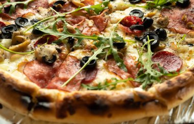 Sosisli ve mozzarellalı lanet bir pizzanın yakın çekimi. Uygunsuz diyet ve aşırı kilo. Yan görünüm.