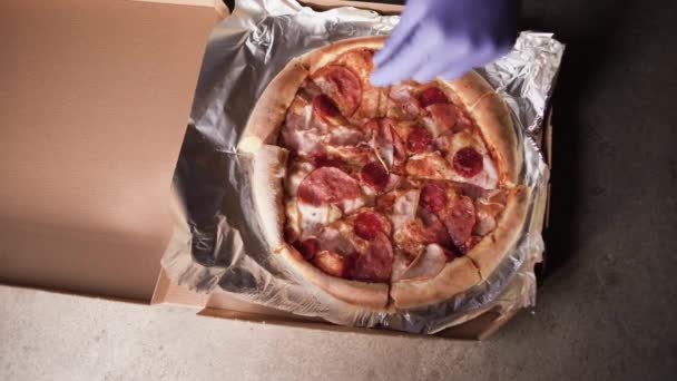 Vedere de sus, mâinile unui bucătar profesionist pune condimente și ierburi pe o pizza proaspăt gătită gata pentru livrare rețetă takeaway carne fierbinte mânca takeaway cutie — Videoclip de stoc