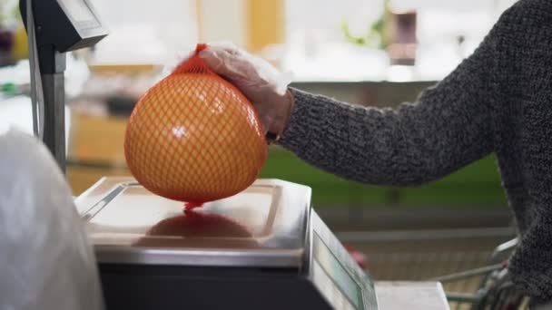 Seorang wanita menimbang jeruk pomelo atau jeruk di toko pada timbangan. Konsep layanan-sendiri — Stok Video