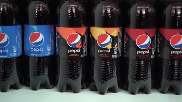 Ukraine, Odessa - January 19, 2021: The famous brand of cola drink PEPSI on the supermarket shelf is up for sale. Womans hand takes one bottle — Stock Video