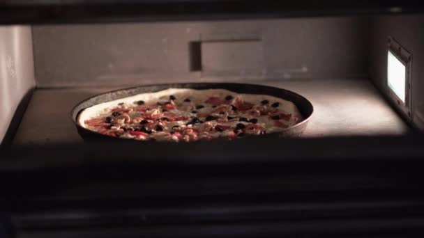 Приготовление пиццы в пиццерии, выпечка неаполитанской пиццы Маргарита в электрической духовке, плавление сыра моцарелла при высокой температуре — стоковое видео