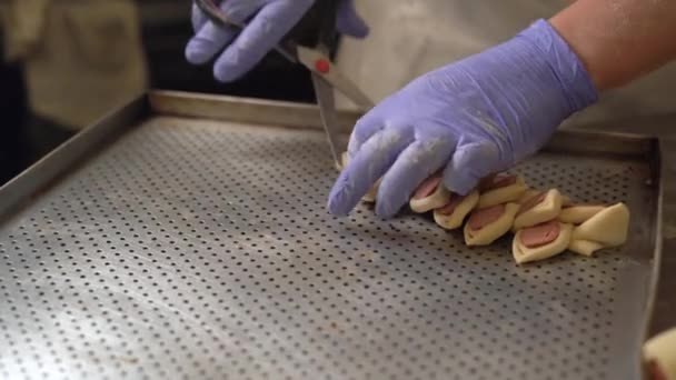 Saucisse en cours de fabrication de tartes à la pâte dans la cuisine de la boulangerie. Boulanger chef professionnel faisant un rouleau d'osier — Video