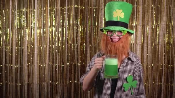 Giovane donna che celebra giorno st patricks, vestito con un costume folletto, tenendo un bicchiere di birra verde tra le mani e sorridente. — Video Stock