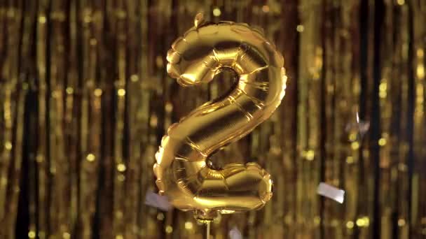 Zlatá fólie číslo 2, dva slavnostní balónky na žlutém pozadí. Koncept narozenin, výročí, datum. — Stock video