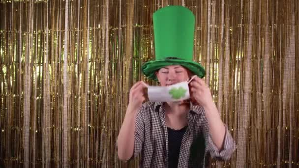 Giovane donna che celebra st patricks giorno vestito in un costume folletto indossa una maschera medica sul suo viso. — Video Stock