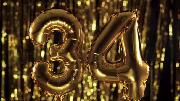 Zlaté číslo 34 třicet čtyři je vyrobeno z nafukovacího balónu na žlutém pozadí. Jedno z kompletních čísel. Narozeniny, výročí, koncept data — Stock video