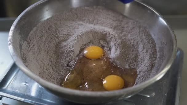 Teig für Schokoladenmuffins machen und Eier in eine große Schüssel werfen — Stockvideo