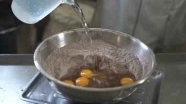 Büyük bir kase un ve kakao şefinin içinde çikolatalı kek pişirmek.