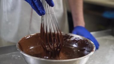 Evde çikolata kreması pişirmek. Erimiş sıcak çikolata. Pasta şefi çırpıcıyı kaldırır.