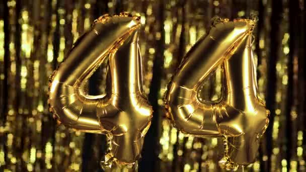 Le nombre d'or 44 quarante-quatre est fait d'une boule gonflable sur un fond jaune. L'un des nombres complets. Anniversaire, concept de date — Video