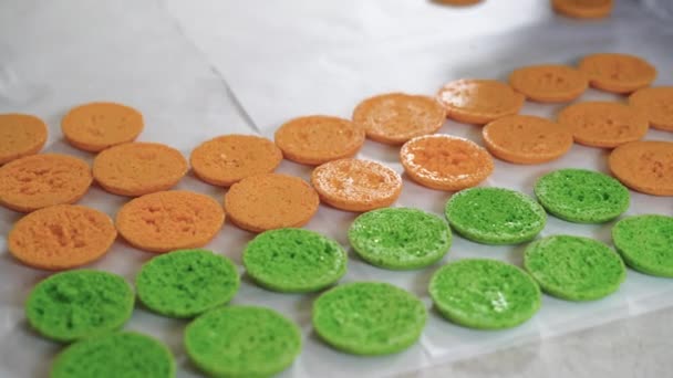 Rozložili jsme hotové makarony na stůl vedle sebe v oranžové a zelené barvě. koncept malého podniku pekařství — Stock video
