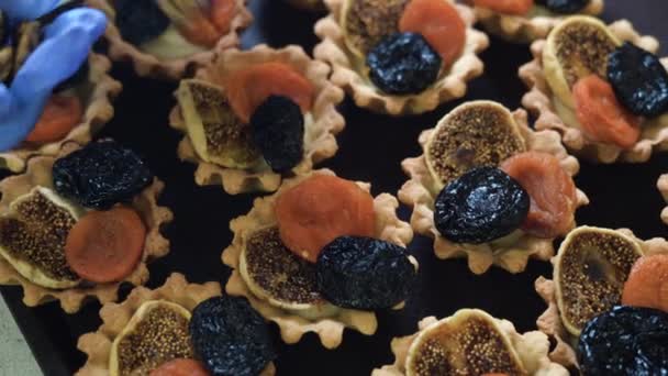 De chef-kok vult de taartjes met pruimen en gedroogde abrikozen met walnoten. Zoetwaren. Zoete desserttaartjes. — Stockvideo