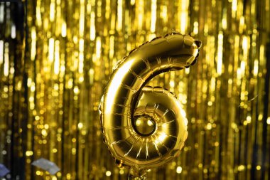 Sarı arka planda 6 numaralı altın folyo altı şenlik balonu. Doğum günü konsepti, yıldönümü.,