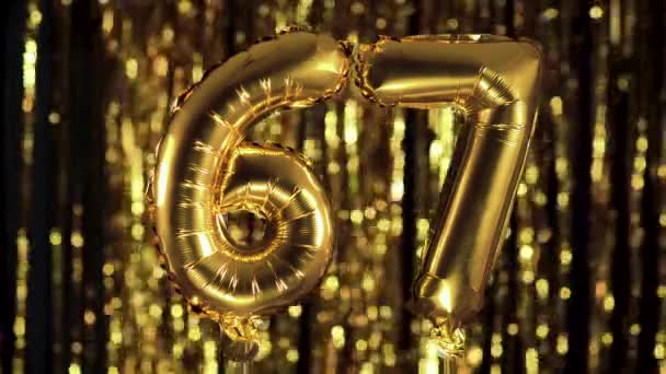 The golden number 67 sixty seven is made from an inflatable balloon on a yellow background. One of the complete set of numbers. Birthday, anniversary, date concept — Stock Video