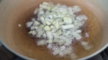 Doğranmış soğanlar kızgın sebze yağıyla kızartma tavasına atılır..