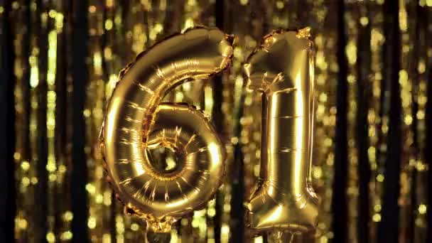 The golden number 61 sixty one is made from an inflatable balloon on a yellow background. One of the complete set of numbers. Birthday, anniversary, date concept — Stock Video