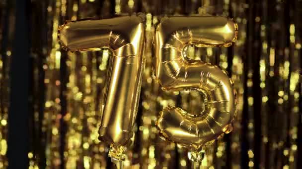 黄金の番号75 75 75は黄色の背景にインフレータブルボールから作られています。数の完全なセットの1つ。誕生日、記念日、日付の概念 — ストック動画