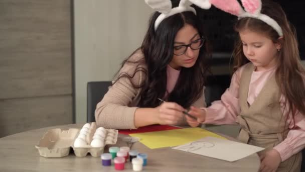 Весела сім'я готується до Великоднього свята мама з донькою намалювали зайця на папері.. — стокове відео