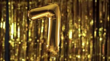 Sarı arka planda 7 numaralı altın folyo yedi numaralı festival balonu. Doğum günü konsepti, yıldönümü, tarih.