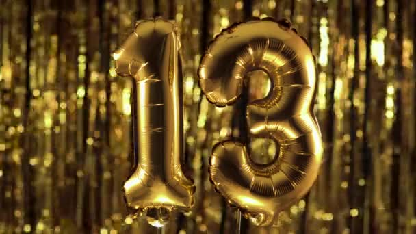 Gullfolie nummer 13, festlig ballong på gul bakgrunn. Begrepet fødselsdag, jubileum, dato. – stockvideo