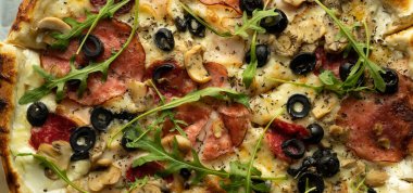 Zeytinli, salamlı, roka ve peynirli bir pizza. Restorandan siparişler geldi. Boşluğu kopyala.