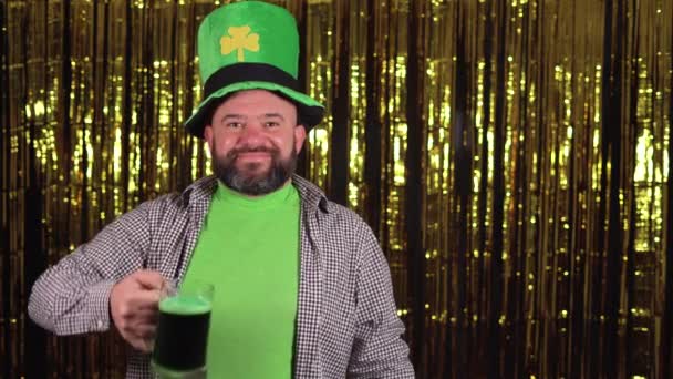 Mannelijke kabouter draagt een grote groene shamrock hoed vieren st patricks dag heft een glas groen bier of ale. — Stockvideo