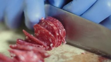 ... ahşap mutfak tahtasıyla salam kesen bir şefin elinde bıçak bulundu..