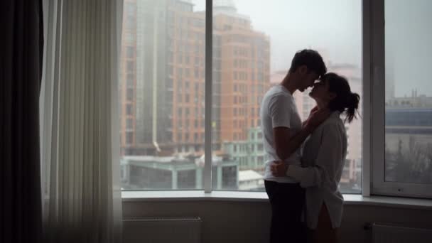 Uomo e donna innamorati di etnia caucasica alla finestra, bacio. Concetto di amore. — Video Stock
