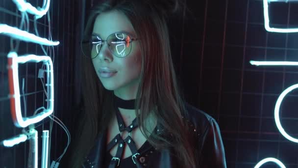 Portrait de fille blanche dans des lunettes. Multicolore en néon chambre noire. Publicité de mode futuriste avec une jeune femme. — Video