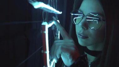 Yakın plan neon model portre. Modaya uygun bir zarafet. Mavi ışıkta poz veren kendine güvenen beyaz kadın. Gece hayatı konsepti.