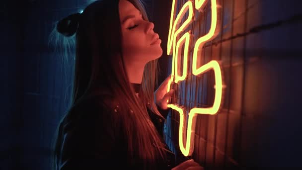 Jovem bela menina caucasiana confiante posando em uma festa perto de lâmpadas de néon. Retrato de close-up. conceito de vida nocturna. Espaço de cópia. — Vídeo de Stock