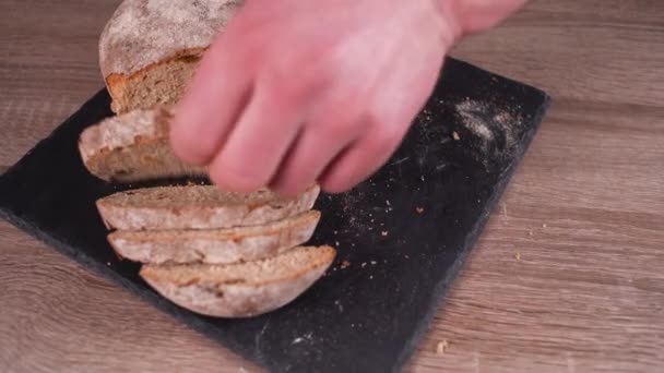 Detailní záběr na mužskou ruku, jak rozmazává pomazánku na plátek žitného chleba. — Stock video