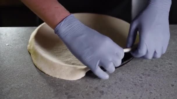 A férfi kezek nyers tésztát raknak egy pizzástálcára. Főzési folyamat. — Stock videók