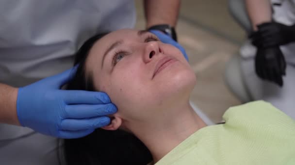 Close-up portret Blanke vrouw patiënt openen en sluiten mond bij tandarts afspraak. De arts doet een onderzoek van de intacte. — Stockvideo