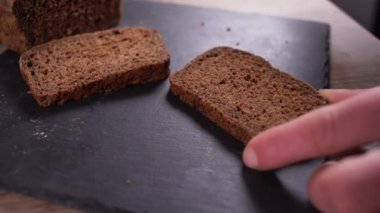 Taze bir çavdar ekmeğine palmiye ağacından yapılmış bir bıçakla serpiştiriliyor..
