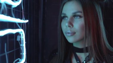 Bir kızın portresi. Karanlık oda neon ışıklarındaki çok renkli. Genç bir kadınla fütürist moda reklamı..