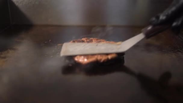 치즈 버거를 만들기 위해 쇠고기와 돼지고기 절임 요리를 한다. 부엌에서 구운 고기. 물기가 많은 고기를 스피 툴라로 누르고 있다. — 비디오