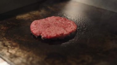 Hamburger için biftek ve domuz pirzolası pişiriyorum. Mutfakta kızartılmış et..